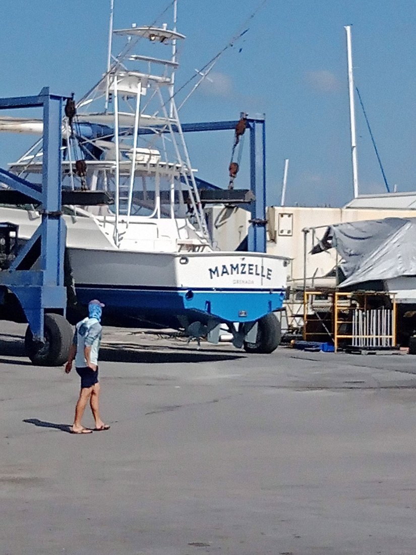 The sportfishing vessel Mamzelle lifted clear of the water in a travelift at a Caribbean boatyard