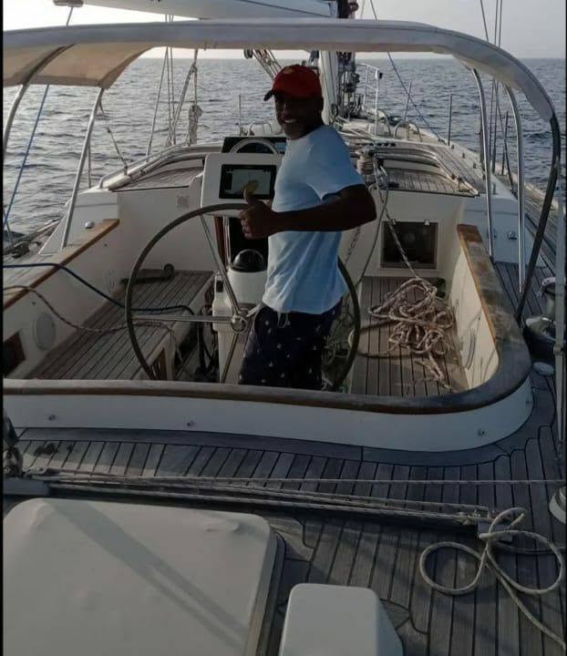 Capt. Troy Benn at the wheel of a sailing yacht under way offshore